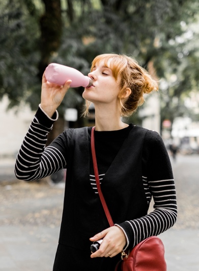 Woman drinking from a reusable bottle